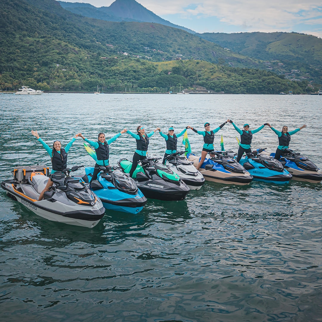 Grupo de pessoas levantando os braços a bordo de modelos Sea-Doo.
